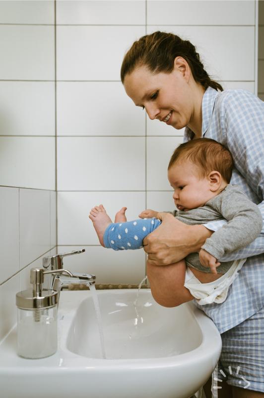 Windelfrei Baby beim Abhalten über Waschbecken